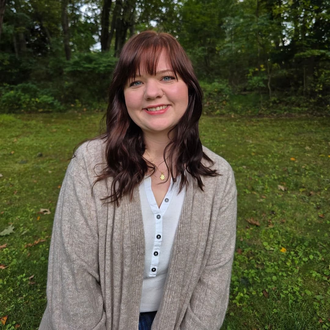 Haley, founder of The Thready Fox, smiling outdoors in a handmade cardigan.